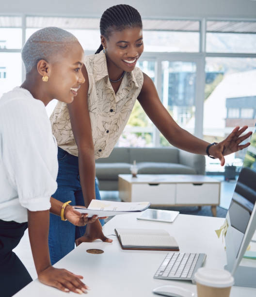 Teamwork, design and collaboration with a creative designer and employee working as a team together in their office at work. Black woman and business partner at work as a team in a modern workplace